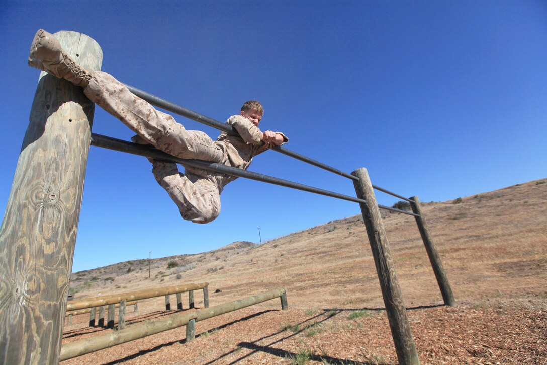Marine Corps Lance Cpl. Austin Anderson climbs an obstacle during the 1st Marine Expeditionary Force Commander's Cup tournament on Camp Pendleton, Calif., April 18, 2013. Anderson, a motor transportation mechanic, is assigned to the 1st Radio Battalion.  
