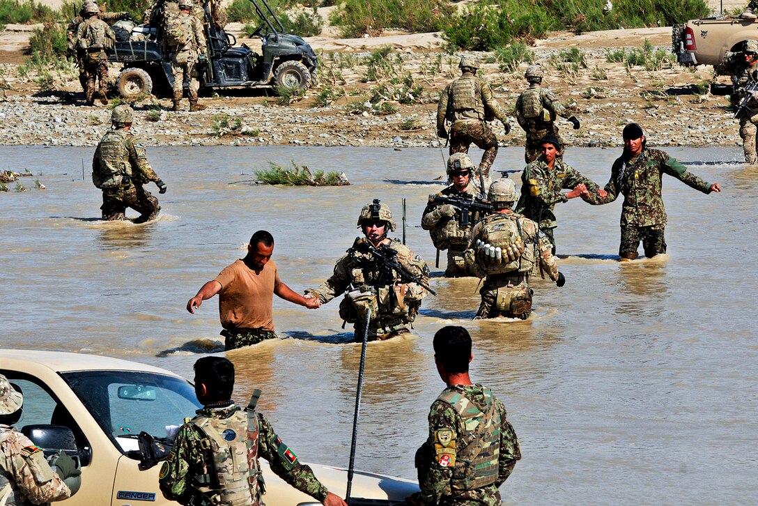 U.S. and Afghan soldiers cross the Tarnak River in the Panjwai district in Afghanistan's Kandahar province, April 10, 2013. The soldiers are assigned to the 2nd Infantry Division's Company C, 1st Battalion, 38th Infantry Regiment. 
