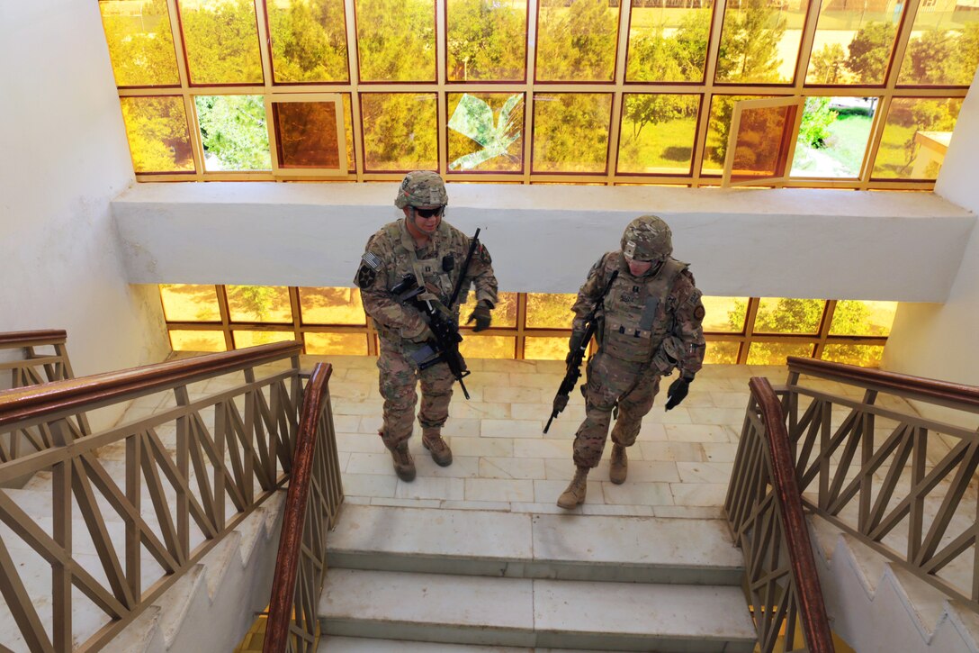 U.S. Army Capt. Jacob Estrada, left, and U.S. Navy Lt. Ronnie Mojzis walk down a staircase in the Farah provincial governor's office building after assessing damage during a meeting with the Farah provincial council in Farah City, Afghanistan, April 11, 2013. Estrada, a security force commander, and Mojzis, an engineer, are assigned to Provincial Reconstruction Team Farah.  
