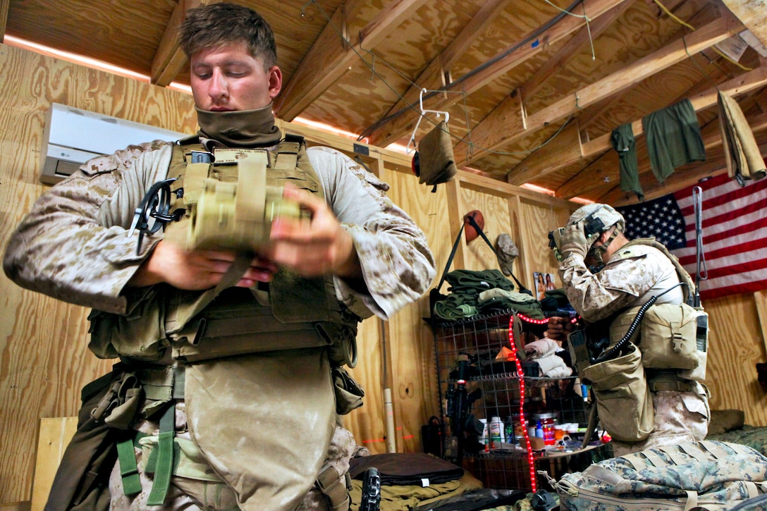 U.S. Marine Corps Lance Cpl. James Brockwell, left, puts on his tactical vest before departing Forward Operating Base Zeebruge on a mounted patrol through the Kajaki district in Afghanistan's Helmand province, April 1, 2013. Brockwell is assigned to the U.S. Marine-led Kajaki Police Advisor Team. 
