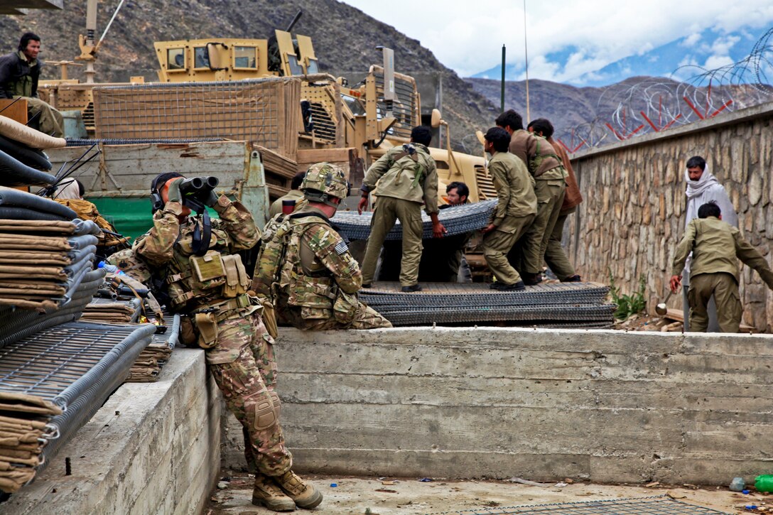 U.S. Army Sgt. Dionicio Montano, left, uses his binoculars to scan a ridge while providing security for a shura at the Marawara District Center in Afghanistan's Kunar province, March 20, 2013. Montano is assigned to the 101st Airborne Division's Integration Detachment Team Hawk, Headquarters Company, 2nd Battalion, 327th Infantry Regiment, 1st Brigade Combat Team.  
