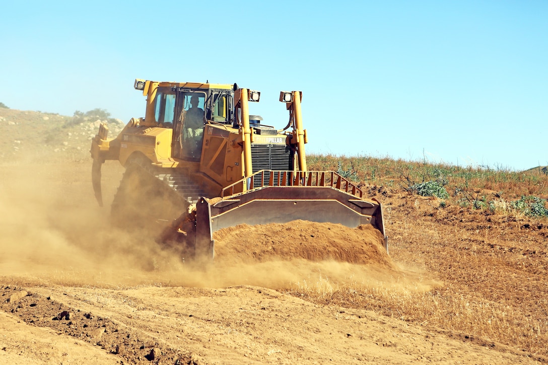 Lance Cpl. Matthew Brown, engineer equipment operator, Support Company, 7th Engineer Support Battalion, 1st Marine Logistics Group, plows brush along a firebreak path using a V8T Dozer aboard Camp Pendleton, Calif., May 13, 2014. Facilities Maintenance Division and seven Marines with 7th ESB, 1st MLG, began creating firebreaks May 6, 2014 in an effort to contain wildfires that may start on base and will continue to create them through Aug. 10, 2014. The FMD employees and 7th ESB Marines are still slated to meet this completion date even with the fire that destroyed 6,000 acres and caused hundreds of service members and their families to evacuate their on-base homes, May 14, 2014.