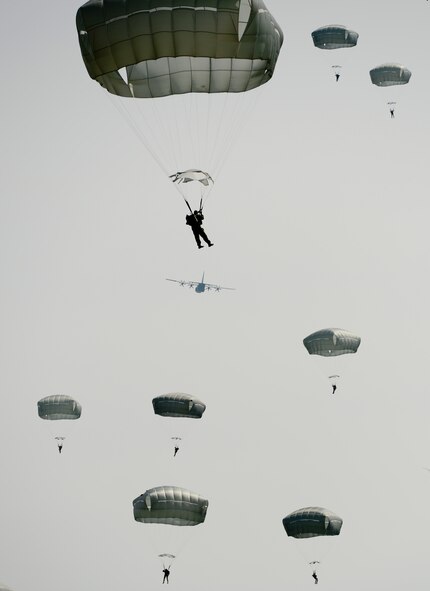 Parachutists descend slowly toward the ground as a C-130 flies off into the distance during International Jump Week May 5, 2014, at the Alzey landing zone, Germany. More than 300 jumpers from nine different nations performed a total of 404 static-line jumps and 132 high altitude low-opening jumps in three days. (U.S. Air Force photo/Airman 1st Class Michael Stuart)