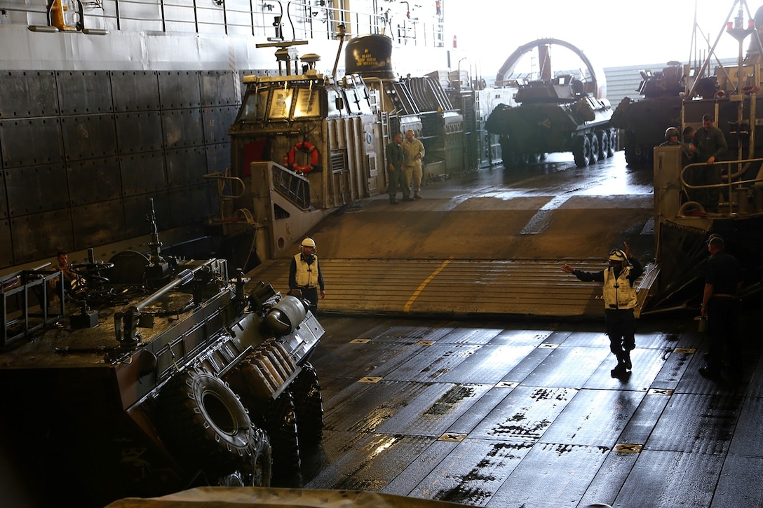 Sailors with the USS San Diego ground guide a light armored vehicle (LAV) off a landing craft air cushion (LCAC) and onto the well deck of the USS San Diego during Composite Training Unit Exercise (COMPTUEX) off the coast of San Diego, May 13, 2014. The 11th MEU and Amphibious Squadron 5 team conduct COMPTUEX to hone mission essential tasks, execute specified MEU and ARG operations, and establish the foundation for a cohesive warfighting team for future exercises and operations. (U.S. Marine Corps photo by Gunnery Sgt. Rome M. Lazarus/Released)