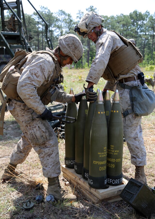 Corporal Nikolas Quintero, a motor vehicle operator, and Lance Cpl Sergio Manzano, a field artillery cannoneer, both with Echo Battery, 2nd Battalion, 10th Marine Regiment, 2nd Marine Division, tighten fuzes onto their artillery rounds before firing the M-777 lightweight 155mm howitzer as part of a Top Gun competition held at Fort Bragg, N.C., May 6, 2014. The competition was part of Rolling Thunder, a biannual field operation in which each battery from 10th Marines comes together to train on their respective weapons systems.