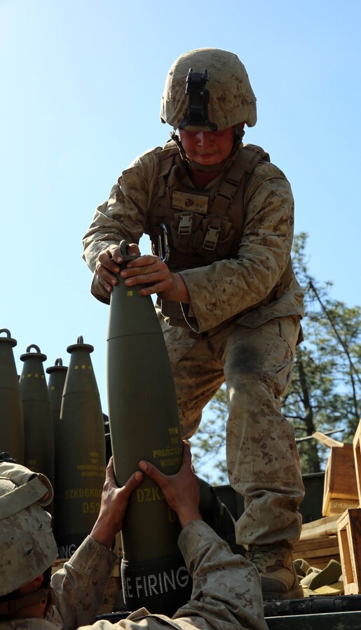 Lance Cpl Easten Fry, an ammunition truck driver with Kilo Battery, 1st Battalion, 10th Marine Regiment, 2nd Marine Division, passes out ammunition for the M-777 lightweight 155mm howitzer during the Top Gun competition held at Fort Bragg, N.C., May 6, 2014. The competition was part of Rolling Thunder, a biannual field operation in which Marines learned to be more proficient at effectively employing their respective weapons systems.