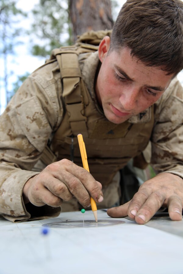 Lance Cpl Wesley Newth, a horizontal chart operator with Golf Battery, 2nd Battalion, 10th Marine Regiment, 2nd Marine Division, plots and checks points on a chart at the fire direction center to ensure accurate fire missions are given to Marines firing the M-777 towed 155mm howitzer at Fort Bragg, N.C., May 7, 2014. The Marines fired the howitzers during a Top Gun competition, the main event of Rolling Thunder, a biannual field operation in which Marines learned to be more proficient at effectively employing their respective weapons systems.