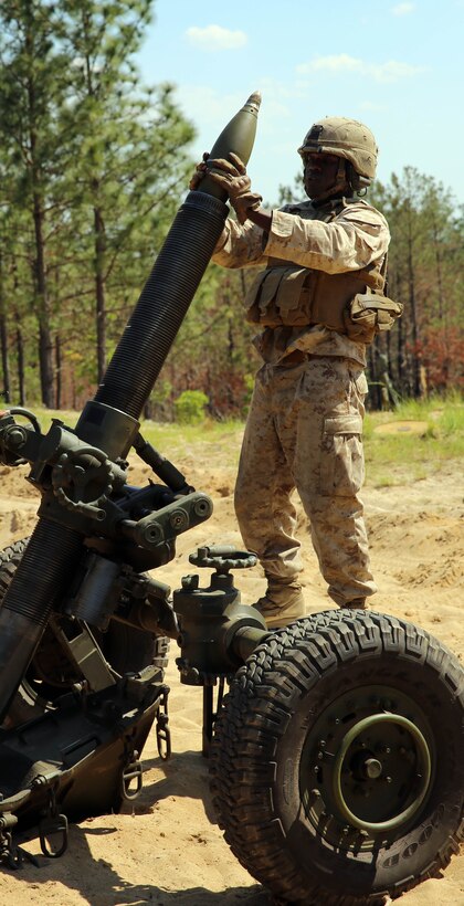 Corporal Winston Dawson, a field artillery cannoneer with Golf Battery, 2nd Battalion, 10th Marine Regiment, 2nd Marine Division, loads ammunition into the M-327 120mm towed rifled mortar expeditionary fire support system before firing during training with Marines from Delta Company, 2nd Assault Amphibian Battalion, 2nd Marine Division, for the field operation Rolling Thunder aboard Fort Bragg, N.C., May 8, 2014. The training with assault amphibious vehicles prepared Marines for getting from ship to shore in a timely manner, while improving their techniques for onloading and offloading the weapons system.