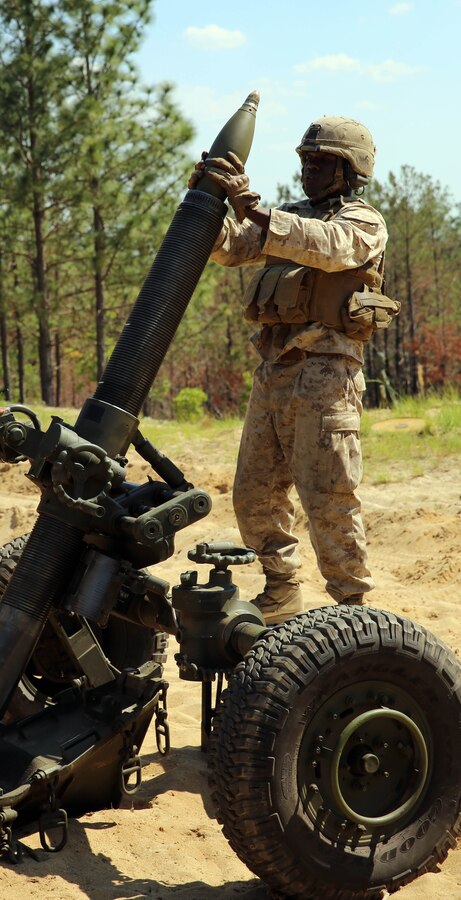 Corporal Winston Dawson, a field artillery cannoneer with Golf Battery, 2nd Battalion, 10th Marine Regiment, 2nd Marine Division, loads ammunition into the M-327 120mm towed rifled mortar expeditionary fire support system before firing during training with Marines from Delta Company, 2nd Assault Amphibian Battalion, 2nd Marine Division, for the field operation Rolling Thunder aboard Fort Bragg, N.C., May 8, 2014. The training with assault amphibious vehicles prepared Marines for getting from ship to shore in a timely manner, while improving their techniques for onloading and offloading the weapons system.