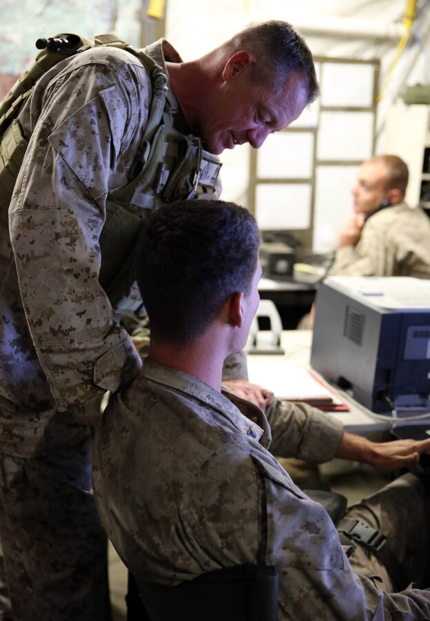 Sergeant Maj. Bryan Zickefoose, sergeant major of 2nd Marine Division, talks to Lance Cpl Tanner Schopman, a fire direction controlman with the combat operations center in 10th Marine Regiment, during a command visit to Fort Bragg, N.C., May 12, 2014. During the visit, Zickefoose and Brig. Gen. James W. Lukeman, commanding general of 2nd Marine Division, observed the work that batteries within 10th Marine Regiment and its supporting units were conducting during Exercise Rolling Thunder.