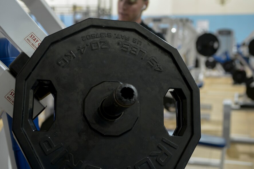 Senior Airman Dakota Beasley, 366th Logistics Readiness Squadron vehicle operator, loads weights onto a bench press machine at Mountain Home Air Force Base, Idaho, May 4, 2014. Fitness is a vital component to Airmen’s readiness. (U.S. Air Force photo by Airman 1st Class Devin Nothstine/RELEASED)