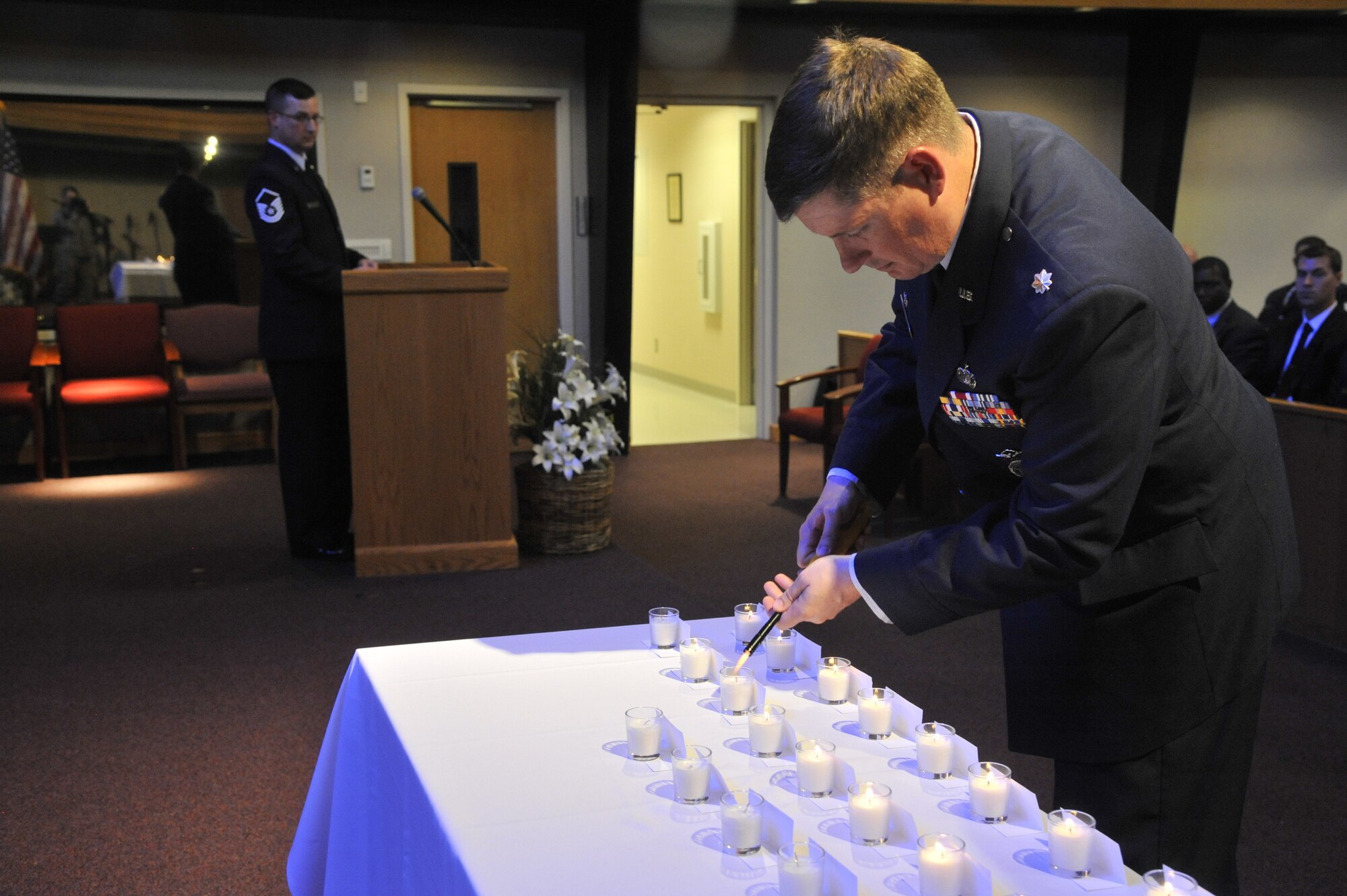 Maj. Eric Horst lights a candle in honor of law enforcement members who lost their lives in the line of duty during a ceremony held at Fairchild Air Force Base, Wash., May 16, 2014. This ceremony was held on Peace Officer's Memorial Day during National Police Week and was one of many events held to bring awareness to law enforcement officers and the sacrifices they have made. Horst is the 92nd Security Forces Squadron commander. (U.S. Air Force photo by Senior Airman Mary O'Dell/Released)