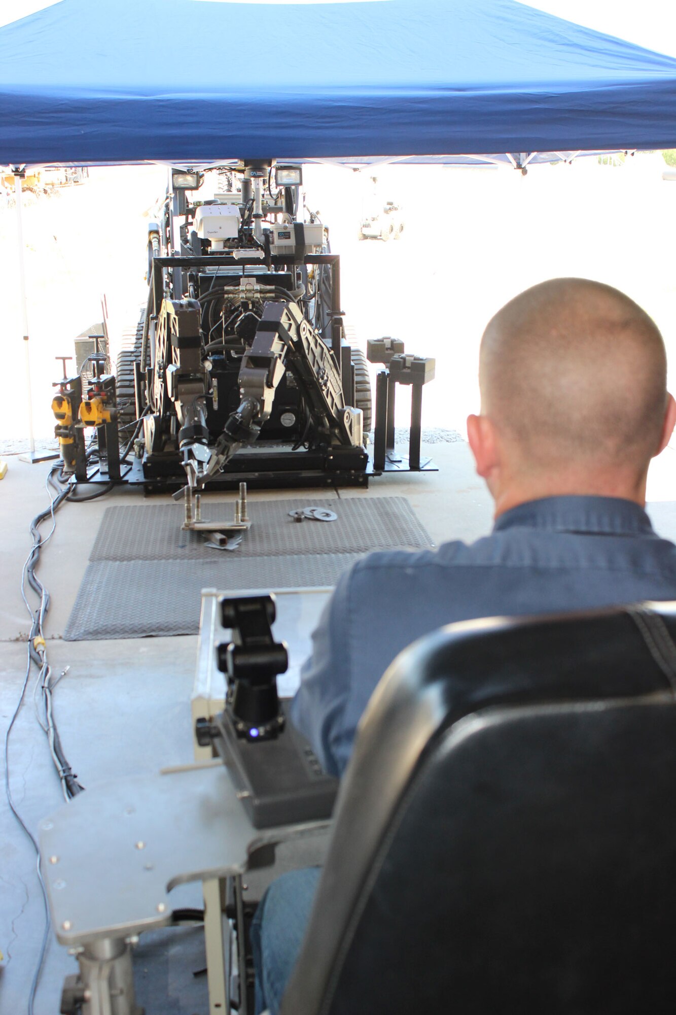 Christopher Walsingham, robotics specialist at the Air Force Civil Engineer Center, Det. 1, Tyndall Air Force Base, Fla., demonstrates the operation of a robotic arm attachment on an All-Purpose Robotic Transport System on May 16, 2014. The demonstration was part of an event that hosted an 18-member delegation from the Japan Defense Technology Foundation. AFCEC held the event as an opportunity to explore areas where the United States and Japan could potentially collaborate on robotic technology. (U.S. Air Force photo/John Burt)