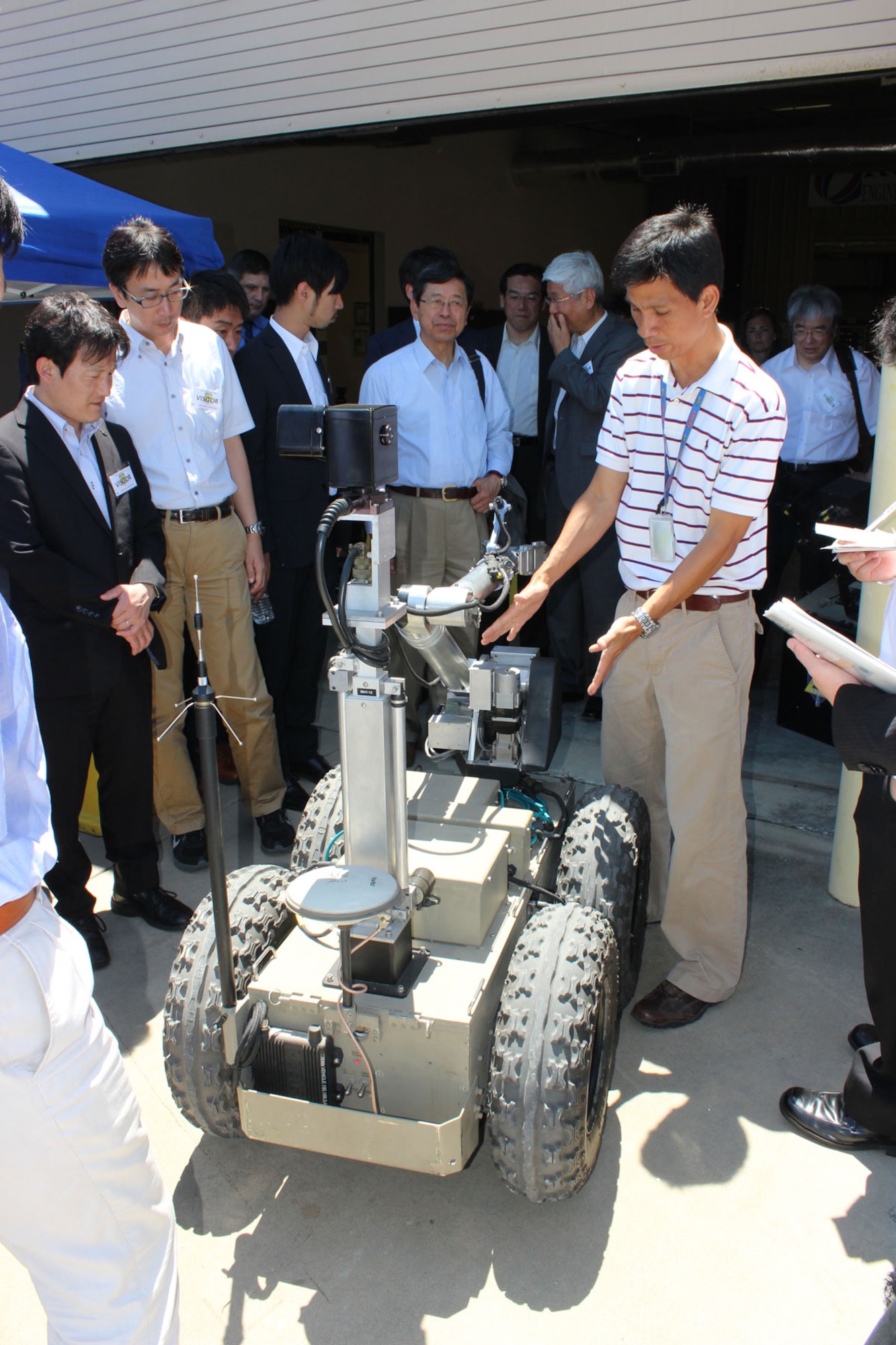 Rommel Mandapat, senior robotics engineer at the Air Force Civil Engineer Center, Detachment 1, Tyndall Air Force Base, Fla., explains features of the Immediate Visual Assessment and Neutralization, or IVAN, robot to members of the Japan Defense Technology Foundation, May 16, 2014. The foundation is composed of members from private industry and provides technical recommendations to Japan’s Ministry of Defense on emerging technologies. AFCEC hosted the event as an opportunity to explore areas where the United States and Japan could potentially collaborate on robotic technology. (U.S. Air Force photo/John Burt)