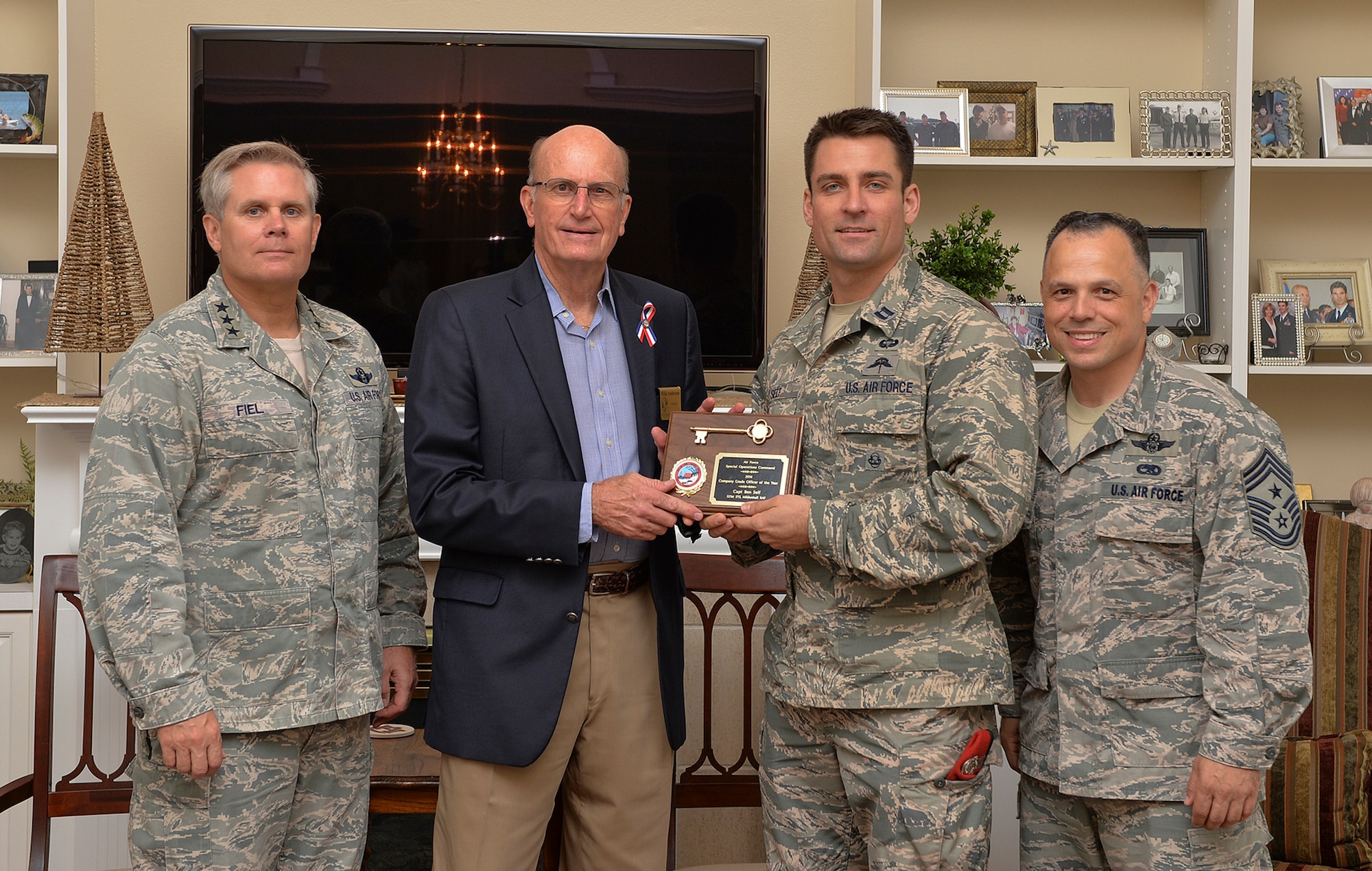 Ft Walton Beach Mayor Mike Anderson presents the key to the city to Capt. Ben Self, a special tactics officer with the 321st Special Tactics Squadron, RAF Mildenhall. Also pictured are Lt. Gen. Eric Fiel, Air Force Special Operations Command commander; and CMSgt. Matthew Caruso, AFSOC command chief.  The mayor presented keys to the AFSOC outstanding Airmen and civilians of the year during breakfast May 13. The OACY recipients spent two days touring Hurlburt Field and were honored during a ceremony held at the Soundside club. (U.S. Air Force photo/Senior Airman Christopher Callaway)