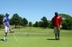 U.S. Air Force Chaplain (Lt. Col.) Marty Fitzgerald, 20th Fighter Wing wing Chaplain (left), watches as Staff Sgt. Jamyal Lett, 20th FW chapel NCO in charge of program management plans his putt on the 18th green during Fitzgerald’s farewell golf tournament at Shaw Air Force Base, S.C., May 16, 2014. Fitzgerald played the 18th hole with every team of Team Shaw members who played in the tournament. (U.S. Air Force photo by Airman 1st Class Jonathan Bass/Released)