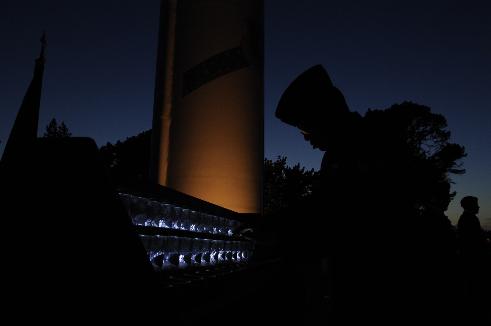 Senior Airman Devin Dotson, 30th Security Force Squadron commander’s support staff, is silhouetted as he lights a ceremonial candle during a vigil, May 15, Vandenberg Air Force Base, Calif. The ceremony was part of National Police Week and commenced with SFS members conducting a 24-hour guard of the vigil and transitioned to the reading of 120 names of those killed in the line of duty, including ten civilian officers. (U.S. Air Force photo by Senior Airman Shane Phipps/Released)
