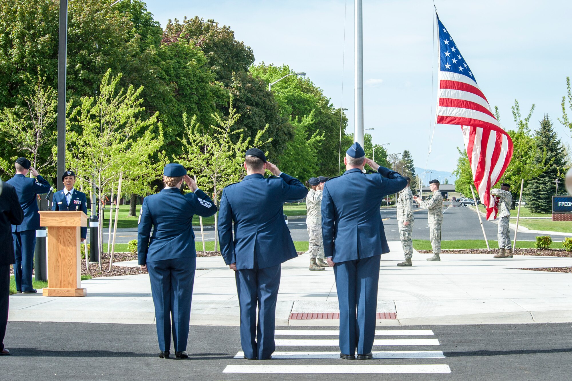 Col. Brian Newberry, Maj. Eric Horst and Chief Master Sgt. Wendy Hansen salute the flag during the singing of the national anthem by Staff Sgt. Denine Deal as part of a special retreat ceremony in honor of National Police Week at Fairchild Air Force Base, Wash., May 15, 2014. This national remembrance week occurs every year in recognition of the service and sacrifice of U.S. law enforcement officers who lost their lives ensuring America’s safety and protection. Newberry is the 92nd Air Refueling Wing commander, Hansen is the 92nd ARW command chief and Horst is the 92nd Security Forces Squadron commander. (U.S. Air Force photo by Staff Sgt. Benjamin W. Stratton/Released)