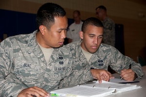 Airman Neil Buac and Airman 1st Class Wesley Michaux, 633rd Civil Engineering Squadron emergency maintenance technicians, review the emergency response plan as part of the table-top exercise, May 15, 2014. “I got a lot out of this exercise,” Buac said. “One day, when I make sergeant, I’ll be the one giving that briefing and it’s good to see how it works first-hand.” (U.S. Air Force photo by Melissa Walther/Released)