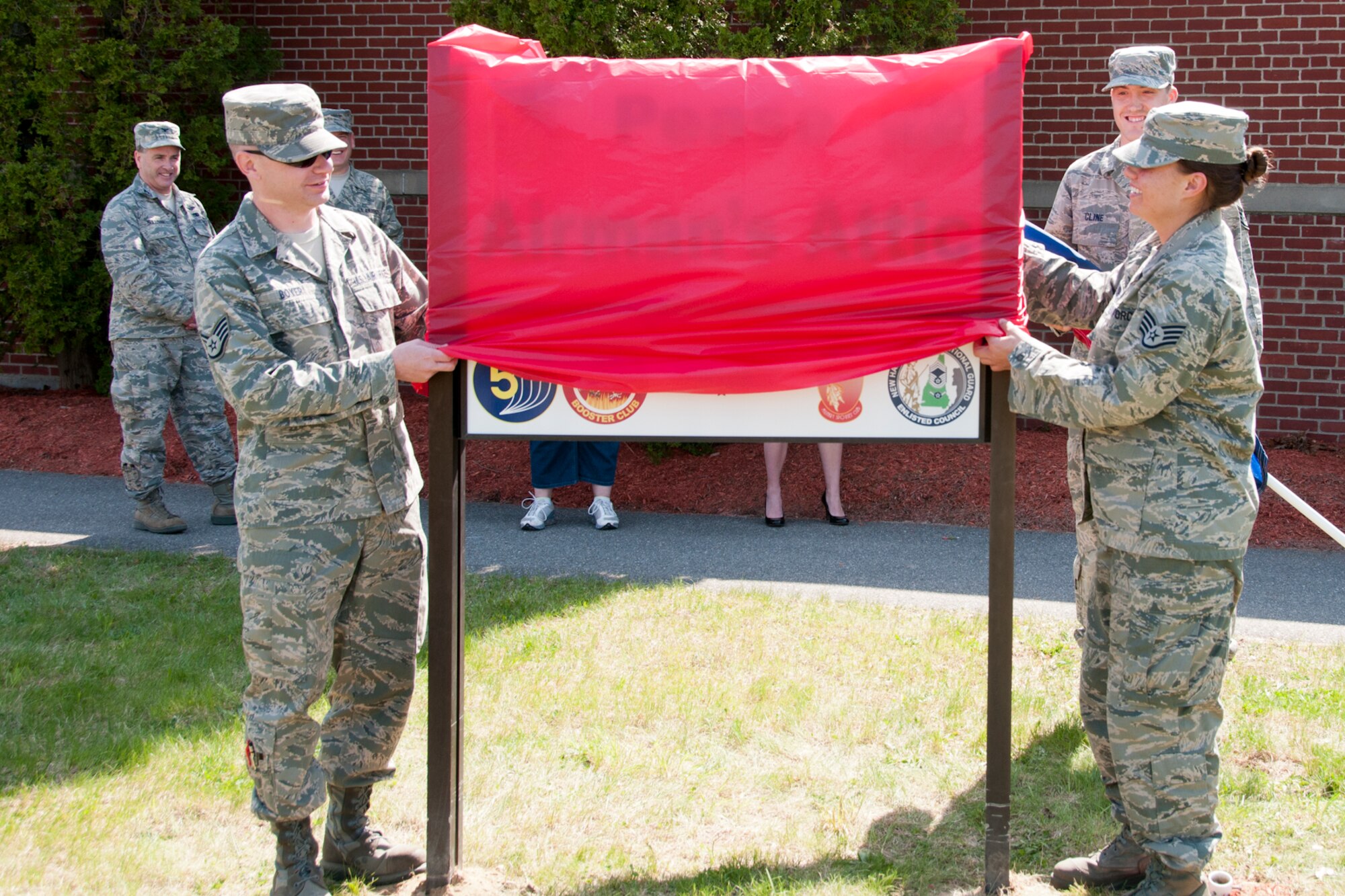 Staff Sgt. Christopher N. Boyer (left) and Staff Sgt. Christine A. Desrochers unveil the Airman’s Attic sign during its grand opening, Pease Air National Guard Base, N.H., May 15, 2014. (U.S. Air National Guard photo by Staff Sgt. Curtis J. Lenz) 