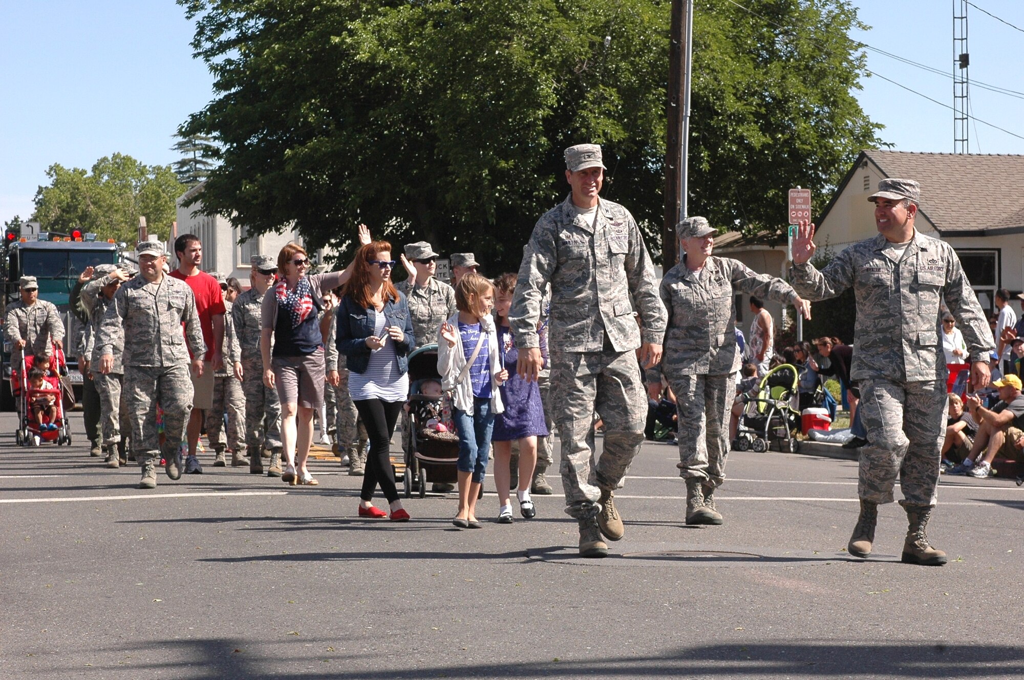 Led by Col. Corey Martin, 60th Air Mobility Wing commander, and Chief Master Sgt. John Evalle, 60th AMW command chief, members of the 60th Wing Staff agencies walked with their families through downtown Dixon as they waived to the thousands of local residents in attendance at the annual Dixon May Fair Parade May 10. (U.S. Air Force photo/Senior Airman Bryan Swink)