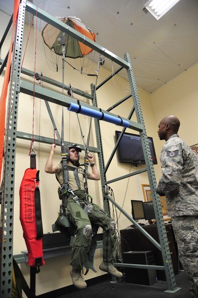 Staff Sgt. Branden Rowe, 56th Operations Support Squadron Aircrew Flight Equipment continuation training NCO-in-charge, guides ROTC Cadet Peyton Sullivan, Arizona State University senior, through steering a parachute to safely land using a parachute simulator May 6 in the aircrew flight equipment building on Luke Air Force Base. AFECT instructors teach students a plethora of survival techniques from safely exiting or ejecting from an aircraft to landing and surviving in Arizona’s wilderness. (U.S. Air Force photo/Senior Airman Grace Lee)