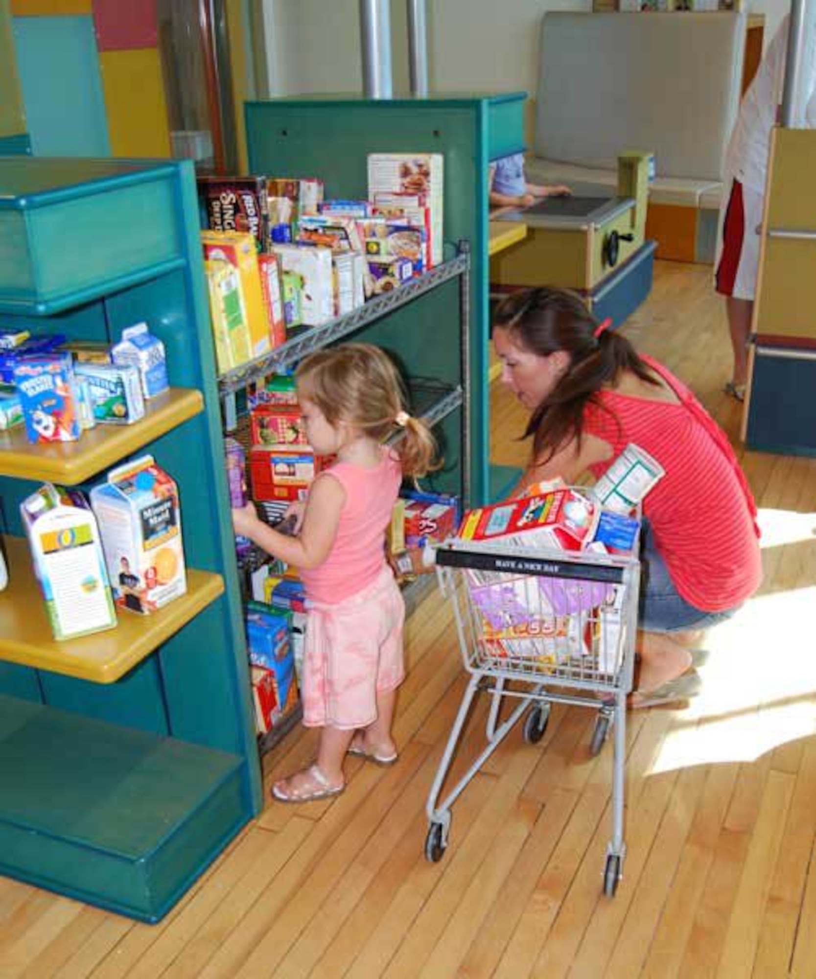 A child shops with her mother at the grocery store at the Children’s Museum of Phoenix. (Courtesy photo)  