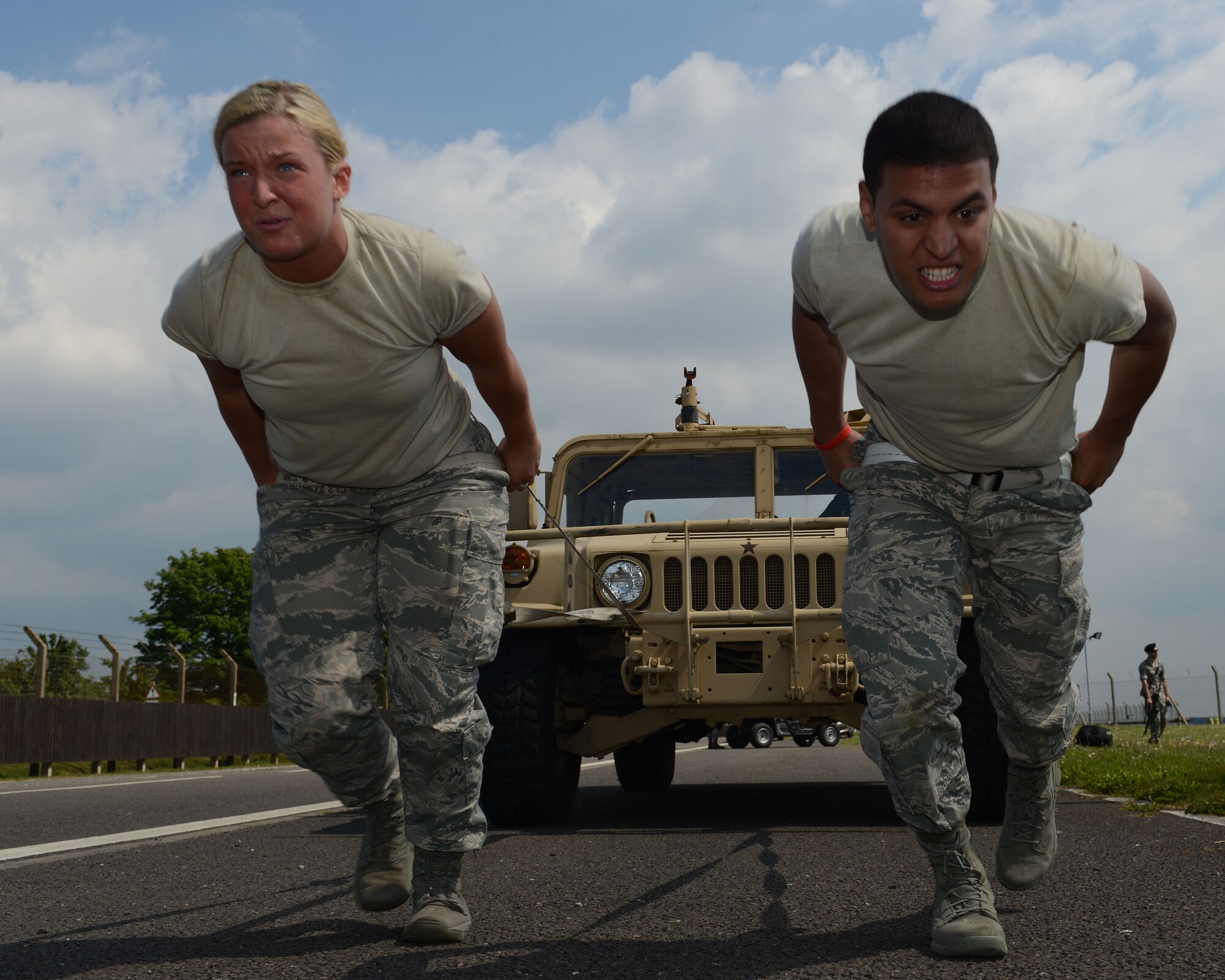U.S. Air Force Airman 1st Class Lauren Miller, left, from Erie, Pa., and U.S. Air Force Airman 1st Class Glenn O. Gonzalez Diaz from Ellington, Conn., both 100th Force Support Squadron career development apprentices, pull a Humvee during the 100th Security Forces Squadron Defender Challenge May 15, 2014, on RAF Mildenhall, England. The 100th SFS welcomed teams from any Team Mildenhall organization to compete alongside defenders during the challenge. (U.S. Air Force photo by Airman 1st Class Preston Webb/Released)