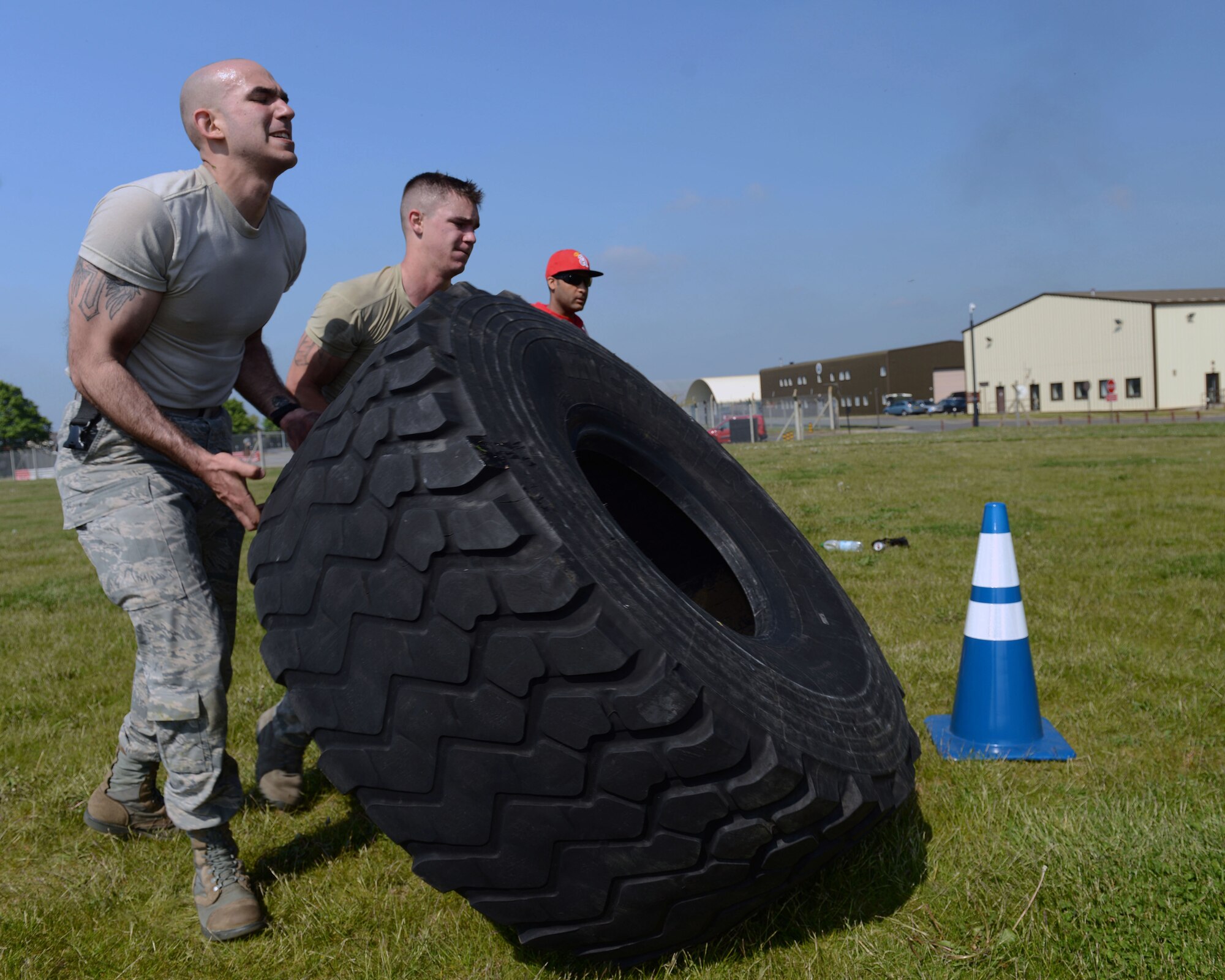 U.S. Air Force Airman 1st Class Roehl A. Chapa Jr., left, 100th Security Forces Squadron computer information specialist from Zapata, Texas, and U.S. Air Force Airman 1st Class Jonathan Mamott, 100th SFS response force member from Cape Coral, Fla., flip a tire during the 100th SFS Defender Challenge May 15, 2014, on RAF Mildenhall, England. The challenge was designed to push Airmen to their limits to test both physical ability and determination. (U.S. Air Force photo by Airman 1st Class Preston Webb/Released)