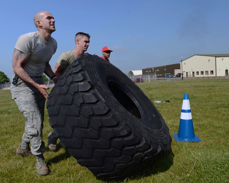 U.S. Air Force Airman 1st Class Roehl A. Chapa Jr., left, 100th Security Forces Squadron computer information specialist from Zapata, Texas, and U.S. Air Force Airman 1st Class Jonathan Mamott, 100th SFS response force member from Cape Coral, Fla., flip a tire during the 100th SFS Defender Challenge May 15, 2014, on RAF Mildenhall, England. The challenge was designed to push Airmen to their limits to test both physical ability and determination. (U.S. Air Force photo by Airman 1st Class Preston Webb/Released)