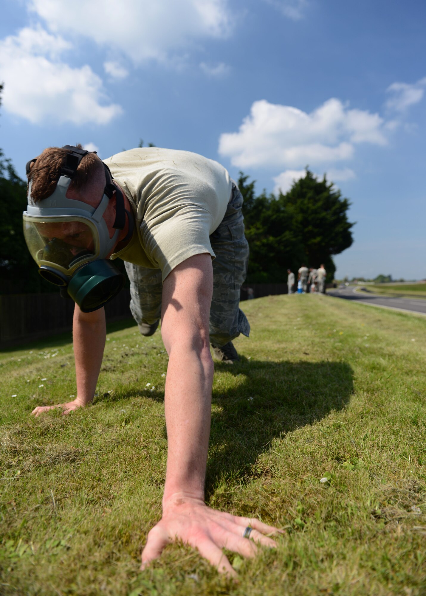U.S. Air Force Staff Sgt. Steven Culver, 100th Security Forces Squadron Military Working Dog handler from Shaboigen, Wis., bear crawls while wearing a gas mask during the 100th SFS Defender Challenge May 15, 2014, on RAF Mildenhall, England. During the event, competitors had to overcome obstacles including a mannequin carry, tire flip, Humvee pull, and blind-folded weapon disassembly and reassembly while running the base perimeter. (U.S. Air Force photo by Airman 1st Class Preston Webb/Released)