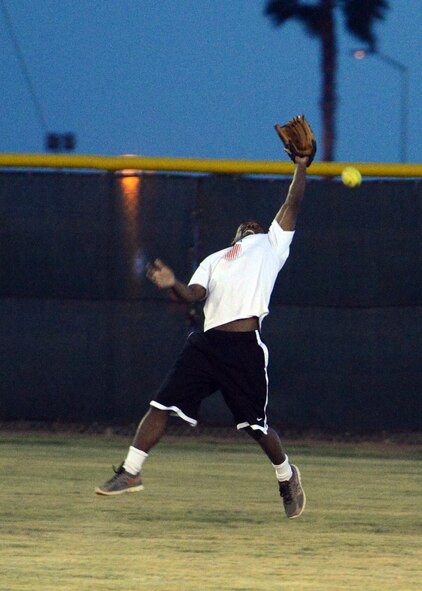 Koraye Williams, 56th Comptroller Squadron, playing for the 56th FWSA team, reaches for a fly ball during an intramural baseball game against 56th COMM. (U.S. Air Force photo/Senior Airman Devante Williams)
