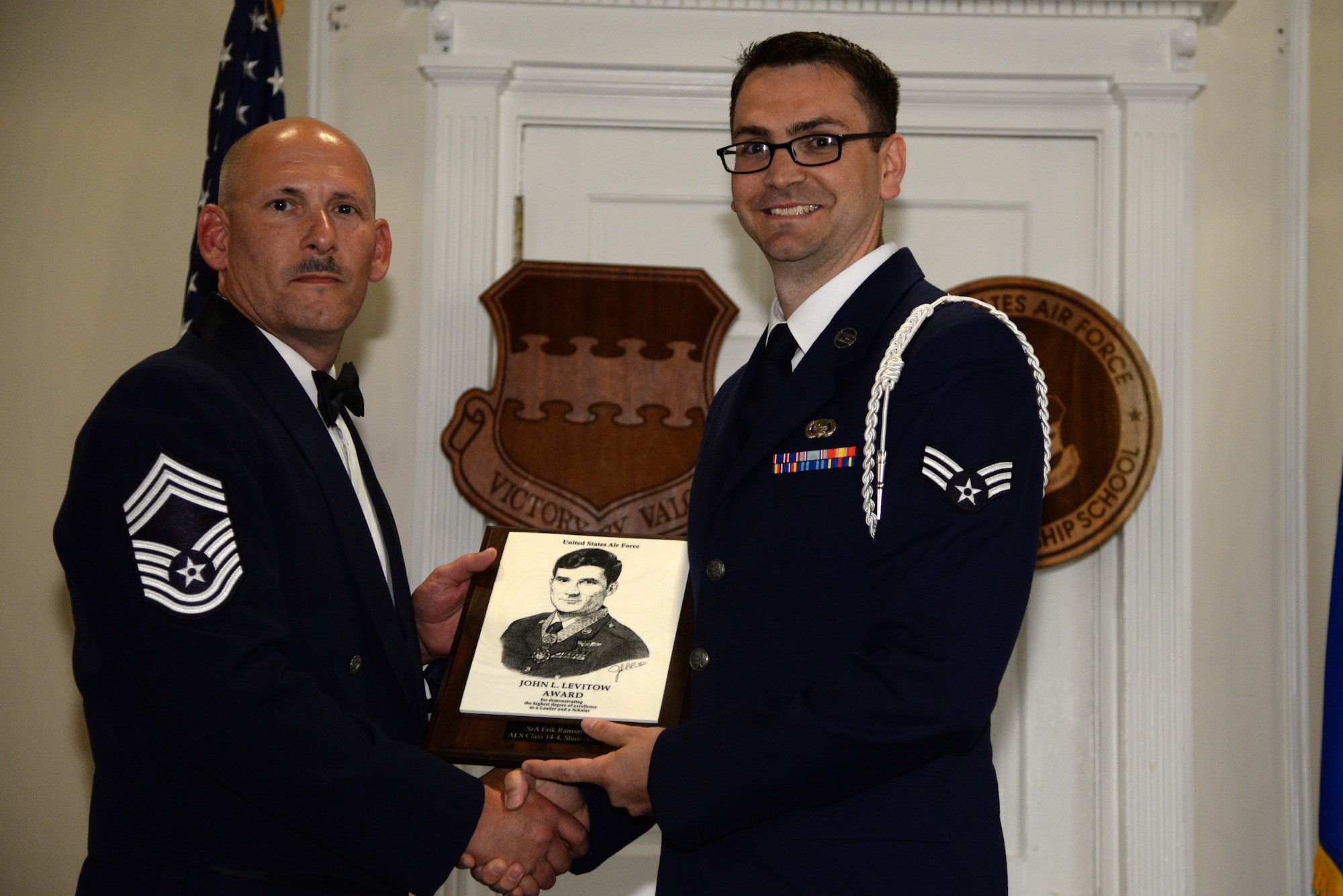 U.S. Air Force Senior Airman Erik Ramsay, 31st Intelligence Squadron (right), receives the John L. Levitow Award for the Senior Master Sgt. David B. Reid Airman Leadership School class 14-4, from Chief Master Sgt. Jerry Dire Jr., U.S. Air Forces Central communications superintendent, at Shaw Air Force Base, S.C., May 15, 2014. The Levitow Award is given to the graduate with the highest average of instructor and student points, and is the highest award in enlisted professional military education. (U.S. Air Force photo by Airman 1st Class Jonathan Bass/Released)