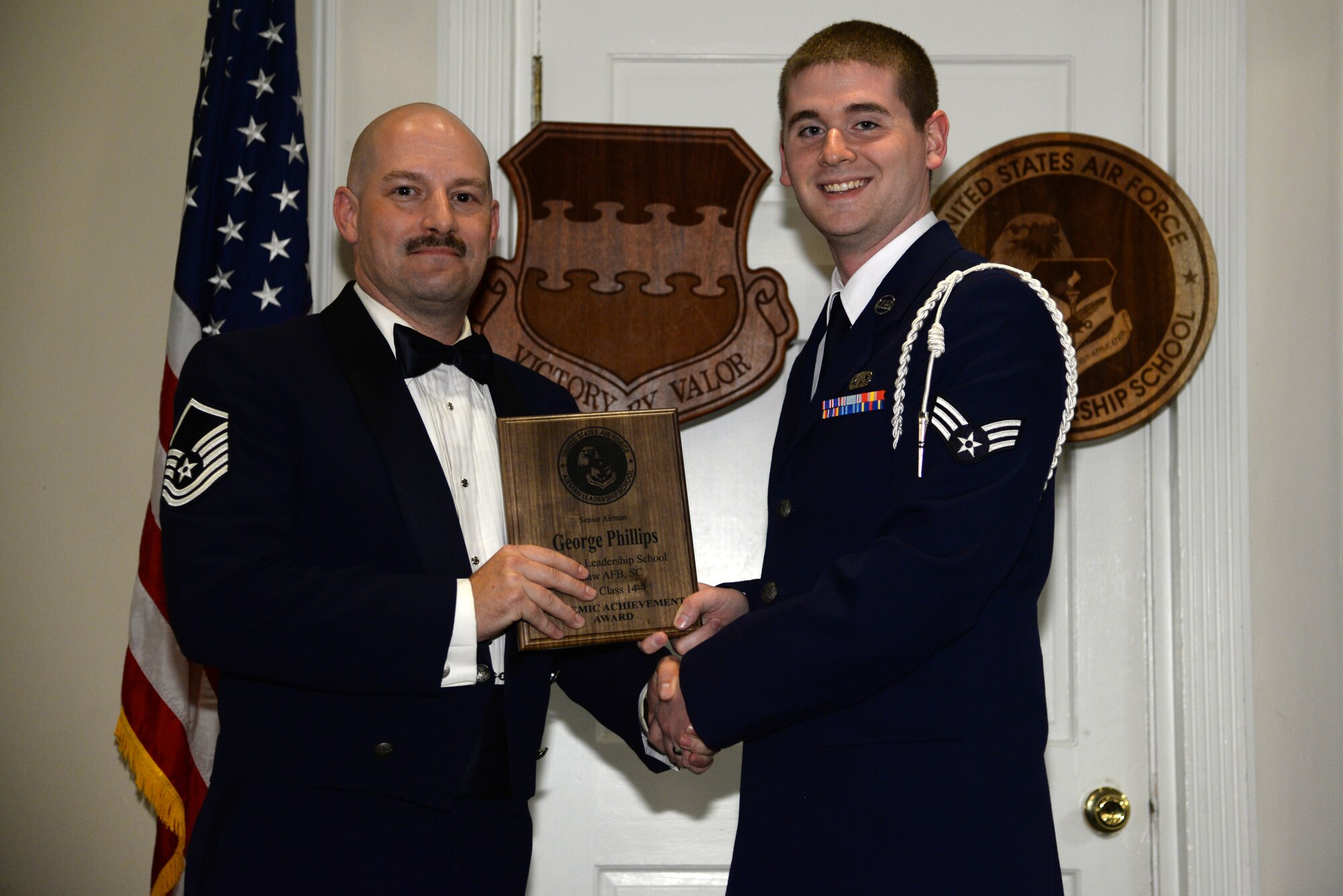 U.S. Air Force Senior Airman George Phillips, 3rd Intelligence Squadron (right), receives the academic achievement Award from Master Sgt. Adam Weinberg, 20th Logistics Readiness Squadron knowledge operations manager, at the Senior Master Sgt. David B. Reid Airman Leadership School class 14-4 graduation at Shaw Air Force Base, S.C., May 15, 2014. This award is given to the student with the highest point total. (U.S. Air Force photo by Airman 1st Class Jonathan Bass/Released)