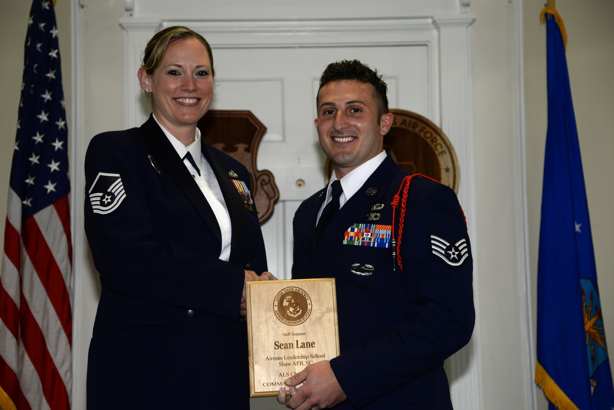 U.S. Air Force Staff Sgt. Sean Lane, 15th Air Support Operations Squadron (right), receives the Senior Master Sgt. David B. Reid Airman Leadership School, Commandant’s Award for class 14-4 from Master Sgt. Lindsey Wolf, 20th Force Support Squadron ALS commandant, at Shaw Air Force Base, S.C., May 15, 2014. The Commandant’s award is given out to the student who most exemplifies professional military qualities as chosen by their peers, the primary instructors, and the ALS commandant. (U.S. Air Force photo by Airman 1st Class Jonathan Bass/Released)