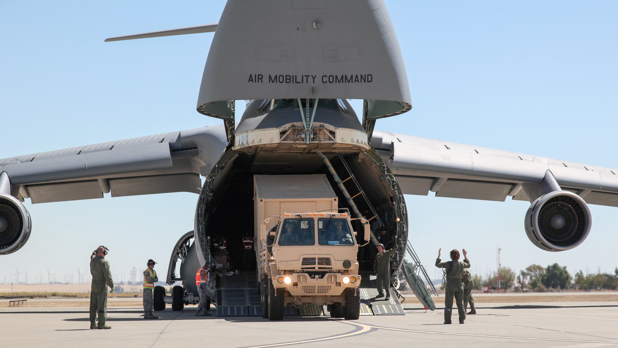 Members of the 312th Airlift Squadron marshal an Army M1083 Standard Cargo Truck with trailer from a C-5B Galaxy during an engine running offload at Travis Air Force Base, California. The 312th AS earned the 2013 Air Force Association Outstanding Reserve Aircrew Award and the 2013 Air Force Reserve Command President’s Award, , according to an announcement from the Air Force Reserve Command Headquarters May 9, 2014 (U.S. Air Force photo/Lt. Col. Robert Couse-Baker)