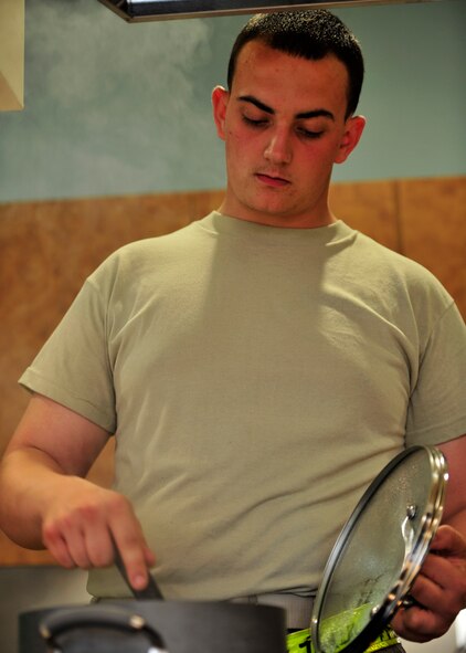 Senior Airman Kenneth Taylor, 436th Aerial Port Squadron ramp operations technician, stirs a cooking pot of coconut rice during a Dorm to Gourm class at the Health and Wellness Center May 13, 2014 at Dover Air Force Base, Del. This is the fourth Dorm to Gourm class that has been offered here and a different meal is prepared each time. (U.S. Air Force photo/Staff Sgt. Elizabeth Morris)