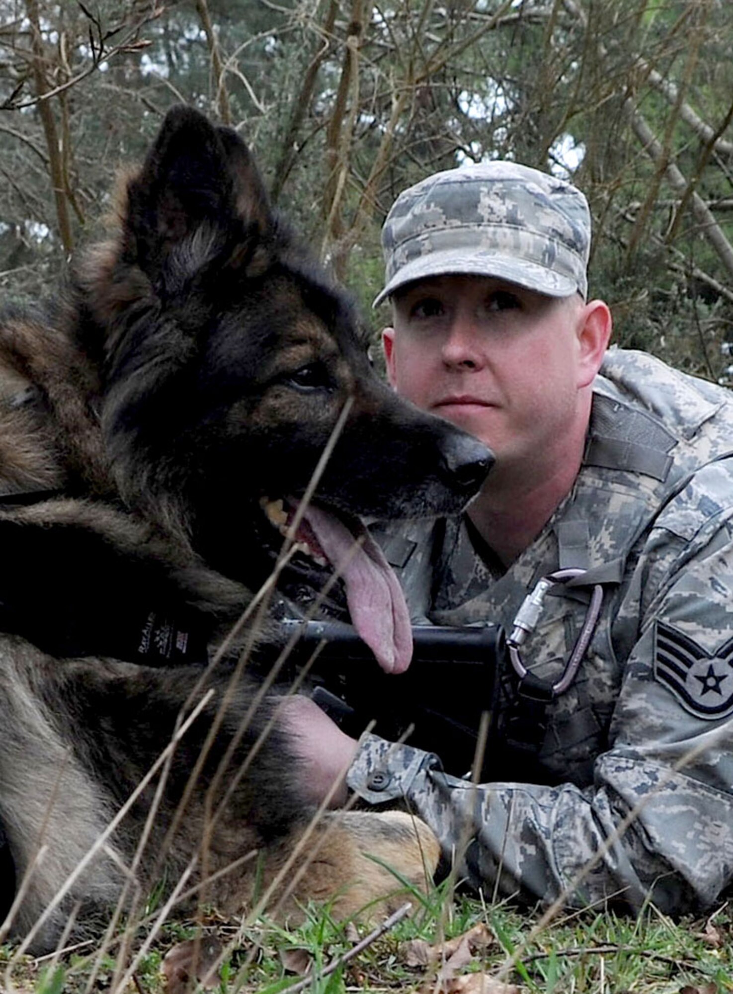 U.S. Air Force Staff Sgt. Adam Smith, 100th Security Forces Squadron Military Working Dog handler, and MWD Ajax survey their area of responsibility during a training exercise April 11, 2014, at Stanford Training Area near Thetford, England. Smith and Ajax watched in each direction to detect adversaries from any direction. It’s important for MWDs to maintain keen senses so they can detect suspects in numerous ways including scent, sight or sound within various enviroments. (U.S. Air Force photo by Senior Airman Kate Maurer/Released)