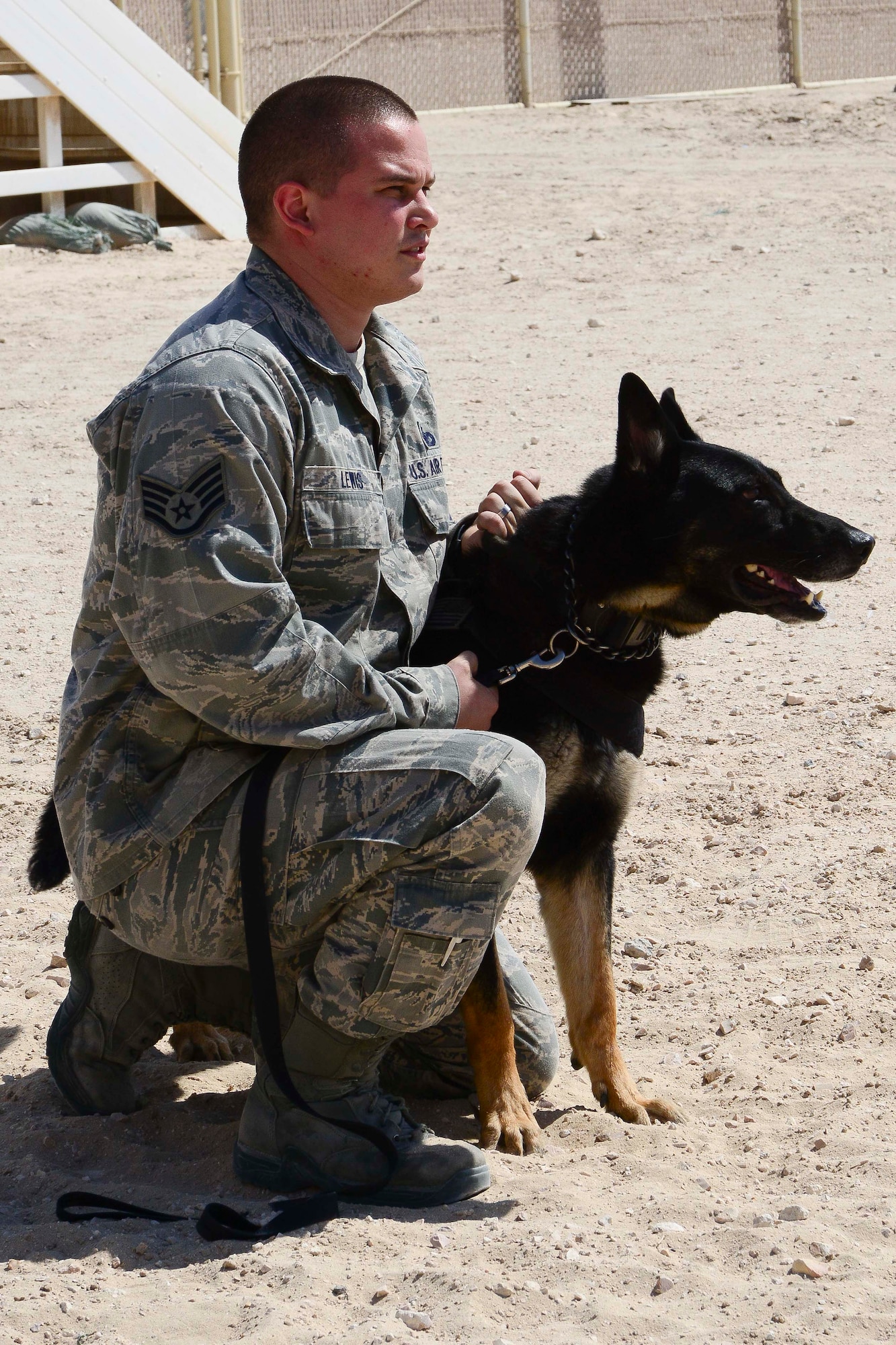 U.S. Air Force Staff Sgt. Nicholas Lewis, 379th Expeditionary Security Forces Squadron military working dog handler, awaits his turn for a K-9 demonstration during National Police Week at Al Udeid Air Base, Qatar, May 16, 2014.  The demonstration showcased the techniques that are used when apprehending suspects.  Lewis is deployed from Dover Air Force Base, Delaware and hails from Galeton, Pennsylvania.  (U.S. Air Force photo by Master Sgt. Marcelo Joniaux)  
