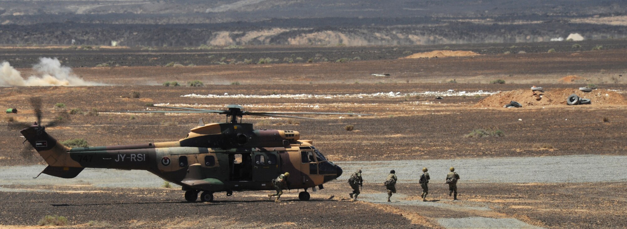 Special operations Service members from the Royal Jordanian Armed Forces unload from an AS332 Super Puma helicopter during a first-run attack competition at Exercise Eager Tiger May 14, 2014, at an air base in northern Jordan. This was the culmination of a week’s worth of friendly competitions between the U.S. and Jordan that aimed to strengthen the countries’ interoperability. (U.S. Air Force photo by Staff Sgt. Brigitte N. Brantley/Released)