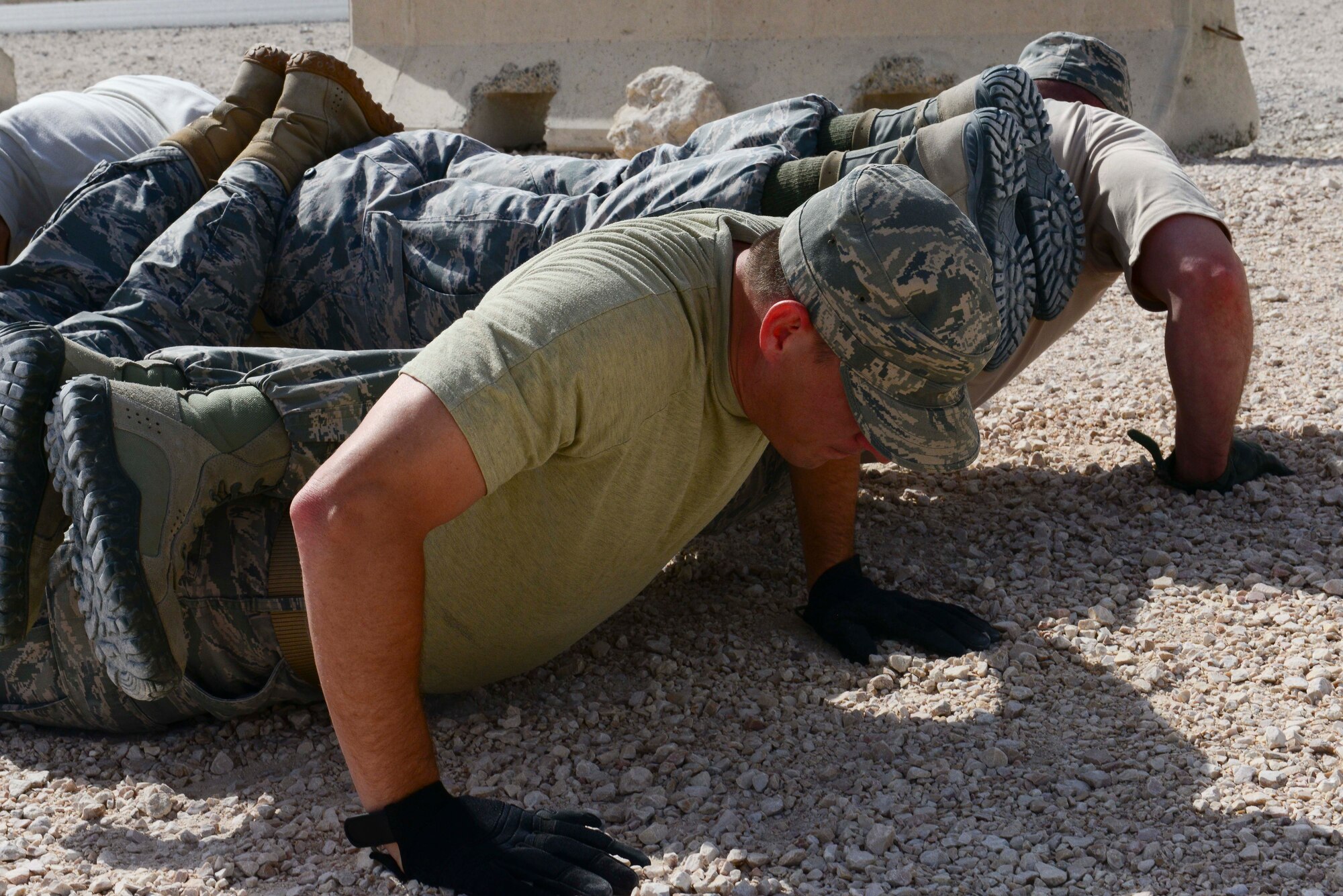 A 379th Expeditionary Security Forces Squadron team completes a four-man push-up as part of an evasion challenge during National Police Week at Al Udeid Air Base, Qatar, May 15, 2014. The National Police Week memorial service began in 1982 as a gathering for survivors and supporters of law enforcement. (U.S. Air Force photo by Staff Sgt. Ciara Wymbs)