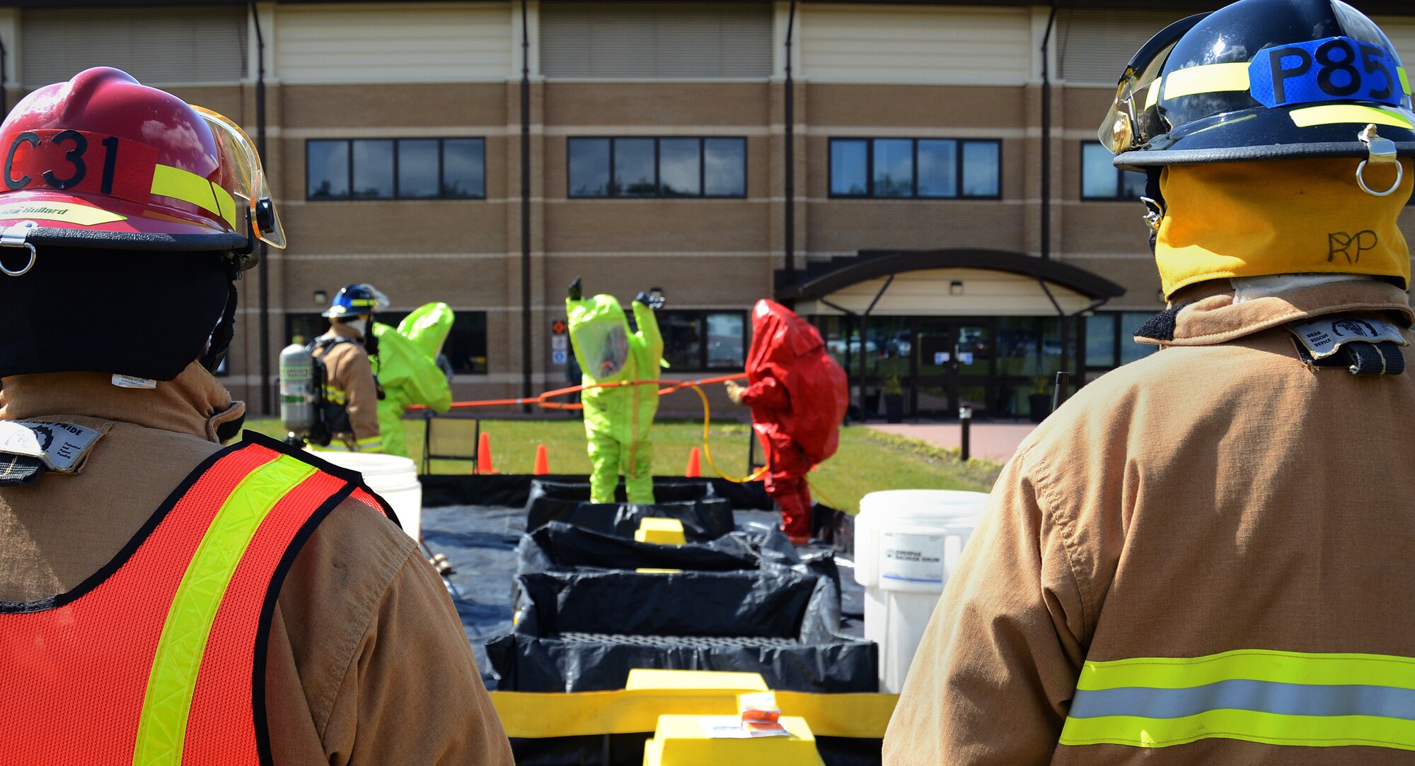 Firefighters from the the 48th Civil Engineer Squadron observe decontamination procedures during a hazardous-material exercise at the 493rd Fighter Squadron, Royal Air Force Lakenheath, England, May 13, 2013. Emergency management and bioenvironmental experts entered the facility to examine a suspicious package as part of the 48th Fighter Wing’s weeklong Unit Effectiveness Inspection. (U.S. Air Force photo by Staff Sgt. Thomas Trower/Released)