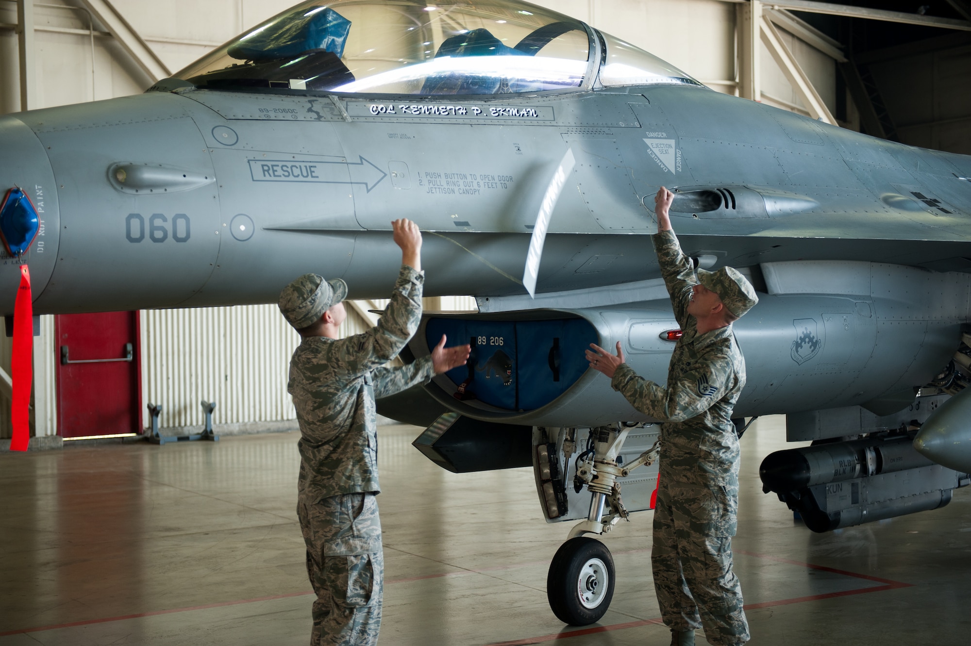 Airman 1st Class Andrew Stefanescu and Staff Sgt. Joshua Smith, 8th Aircraft Maintenance Squadron crew chiefs, unveil Col. Kenneth Ekman's, 8th Fighter Wing commander, name on his F-16 Fighting Falcon during the 8th FW change of command ceremony at Kunsan Air Base, Republic of Korea, May 16, 2014. Col. S. Clinton Hinote relinquished command to Ekman. (U.S. Air Force photo by Staff Sgt. Clayton Lenhardt/Released)