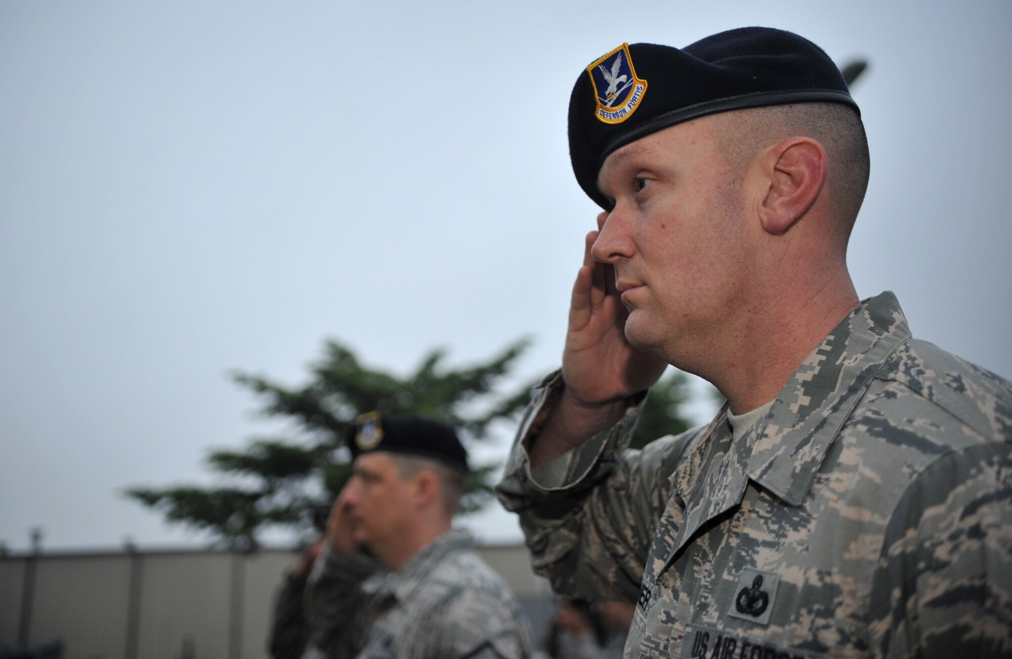 Members of the 51st Security Forces Squadron render salutes to the American flag during the Police Week reveille ceremony at Osan Air Base, Republic of Korea, May 12, 2014. Nearly 70 defenders and members of the Office of Special Investigations took part in the formation and flag detail. (U.S. Air Force photo/Airman 1st Class Ashley J. Thum)