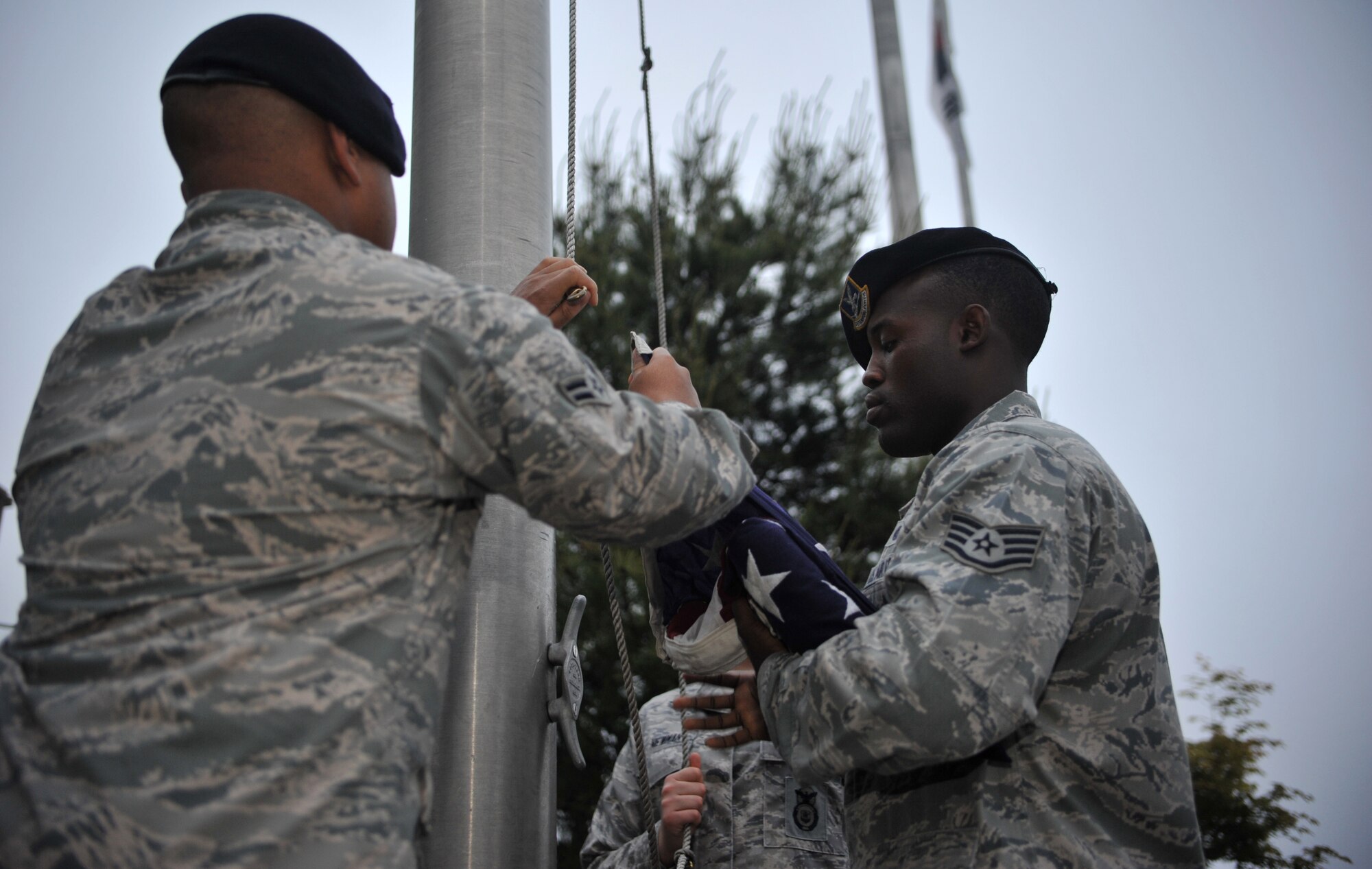 Members of the 51st Security Forces Squadron prepare to hoist the American flag during the Police Week reveille ceremony at Osan Air Base, Republic of Korea, May 12, 2014. Proper flag etiquette mandates the flag be hoisted briskly and lowered solemnly. (U.S. Air Force photo/Airman 1st Class Ashley J. Thum)