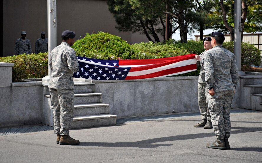 Airmen from the 51st Security Forces Squadron fold the American Flag during the Police Week retreat ceremony at Osan Air Base, Republic of Korea, May 16, 2014. Retreat traditionally signals the end of the duty day on military installations. (U.S. Air Force photo/Airman 1st Class Ashley J. Thum)