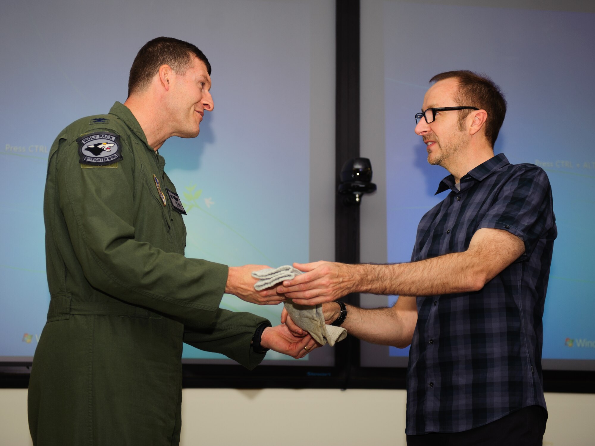 Col. S. Clinton Hinote, Wolf 53 and previous 8th Fighter Wing commander, is presented retired Air Force Brig. Gen. Robin Olds’ lucky socks by John Dibbs, The Plane Picture Company creative director and friend of Olds, at Kunsan Air Base, Republic of Korea, May 13, 2014. Dibbs presented the memento to be cared for by the Wolf Pack and inspire future leaders. Olds, known as “Wolf 1,” reportedly wore the socks during every mission he flew. (U.S. Air Force photo by Senior Airman Armando A. Schwier-Morales/Released)