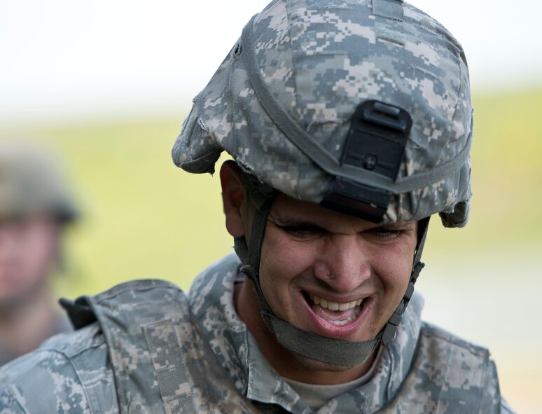 U.S. Air Force Senior Airman Roberto Caceras, 52nd Security Forces Squadron patrolman, struggles while carrying a teammate during the 52nd Security Forces Squadron National Police Week decathlon at Spangdahlem Air Base, Germany, May 14, 2014. The litter carry was one of the stations spread out along a 3.5 mile course, ending with a timed tactical scenario where members cleared a house with simulated ammunition. The winning team was from the 52nd SFS police services section. (U.S. Air Force photo by Staff Sgt. Chad Warren/Released)