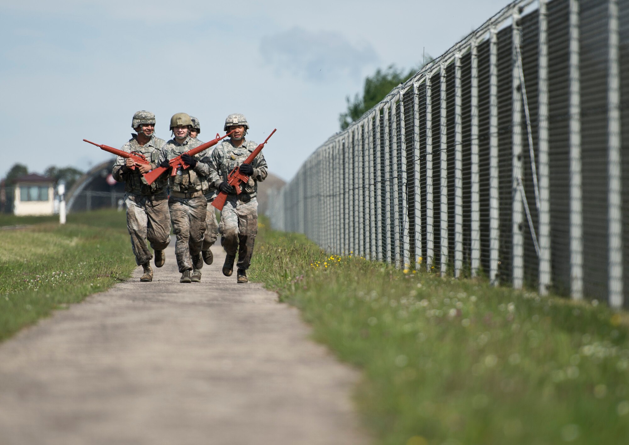 A team runs between stations during the 52nd Security Forces Squadron National Police Week decathlon at Spangdahlem Air Base, Germany, May 14, 2014. The event consisted of 10 stations spread out along a 3.5 mile course, including team push-ups, a litter carry and low crawling through the mud. The winning team was from the 52nd SFS police services section. (U.S. Air Force photo by Staff Sgt. Chad Warren/Released)