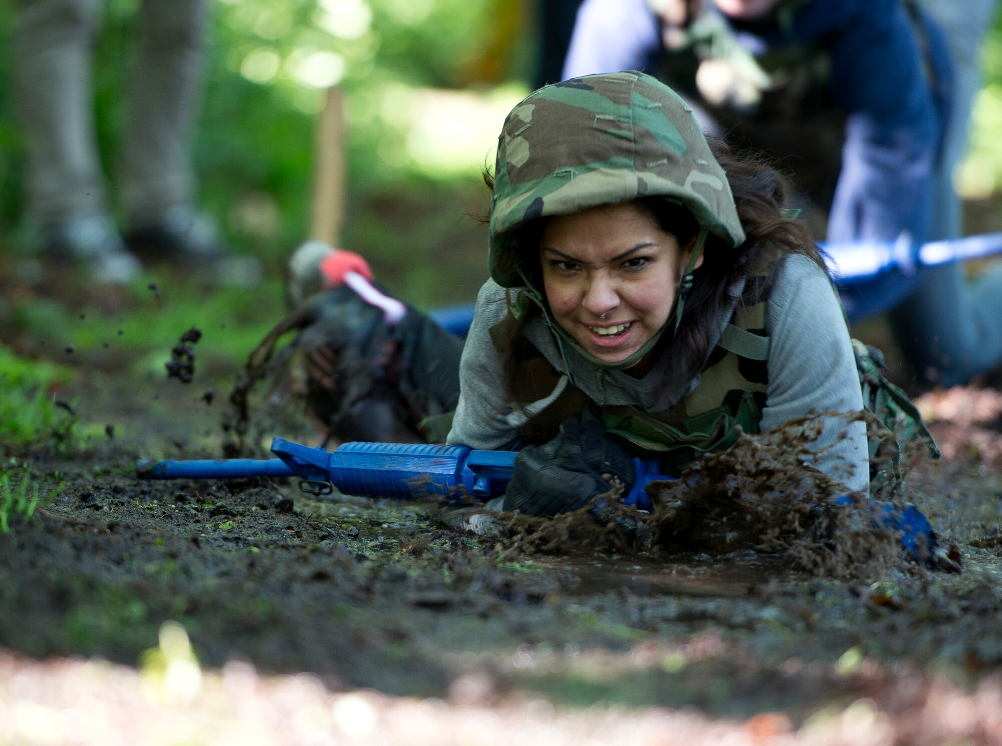 Abby Sanchez, wife of U.S. Air Force Airman 1st Class Santos Sanchez, low crawls through the mud during the 52nd Security Forces Squadron National Police Week decathlon at Spangdahlem Air Base, Germany, May 14, 2014. One team of competitors was comprised entirely of spouses. The winning team was from the 52nd SFS police services section. (U.S. Air Force photo by Staff Sgt. Chad Warren/Released)